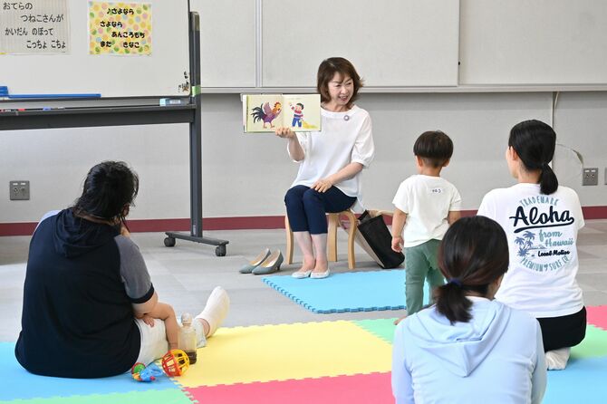 参加者に絵本を読み聞かせる高橋さん＝６月、宇都宮市中里町