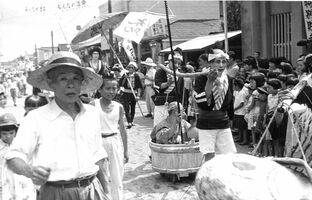 １９５５～６０年ごろに黒田原駅前通りで行われた仮装行列（金子弘行さん提供）