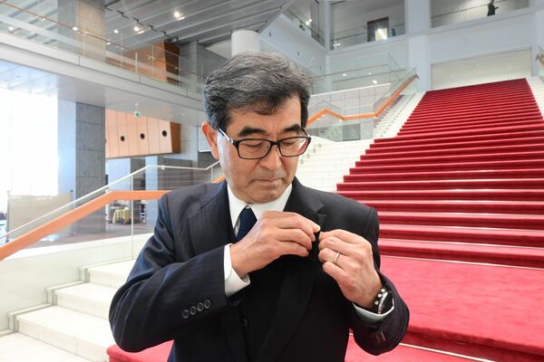 議員バッジを胸に着ける大貫氏＝19日午前、県議会議事堂