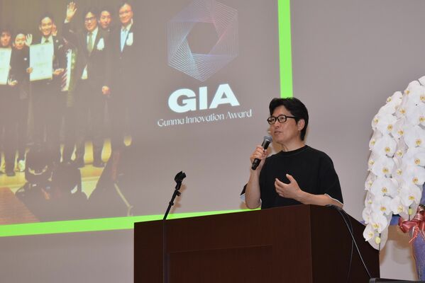 「JINSと地域活性化」をテーマに講演する田中CEO＝19日夕、宇都宮市