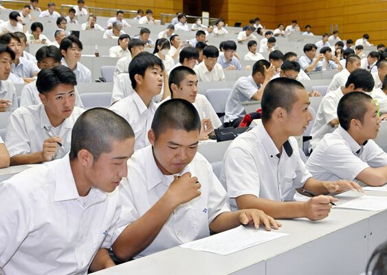 手元のトーナメント表を見ながら抽選の様子を見守る各チームの選手たち＝県総合教育センター