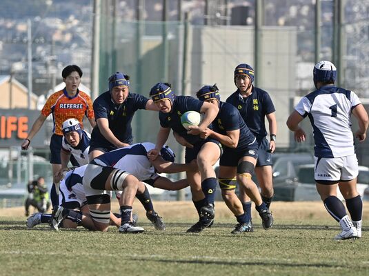 ２回戦の明和県央（群馬）戦　前半17分、国学栃木の金子（中央）が攻め込む＝30日、大阪府東大阪市の花園ラグビー場、広瀬華撮影