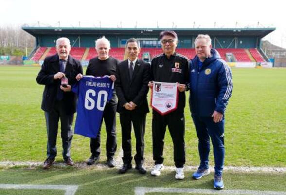 　スコットランドのスターリングの本拠地を訪問し、関係者と写真に納まる日本サッカー協会の山本ナショナルチームダイレクター（右から２人目）。左端はジョン・オールさん＝２４日、スターリング（共同）