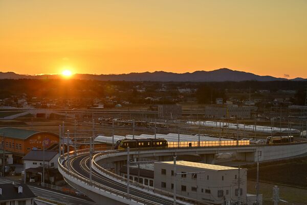 八溝山地からの初日の出と高架橋で停車する列車＝１日午前６時55分、宇都宮市陽東５丁目