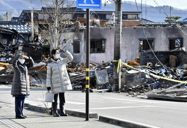 火災で焼失した「輪島朝市」の様子を確認する被災者ら＝14日午後１時45分、石川県輪島市