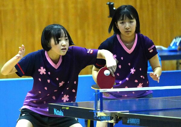 卓球女子団体決勝　真女の三村（左）がバックハンドを放つ。奥は園部＝宇都宮市体育館、橋本裕太撮影