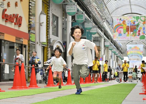 オリオン通りの特設コースを走る子どもたち＝15日午前11時50分、宇都宮市江野町