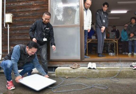 　衛星インターネットサービス「スターリンク」を設置する住民ら＝２日午前、石川県かほく市