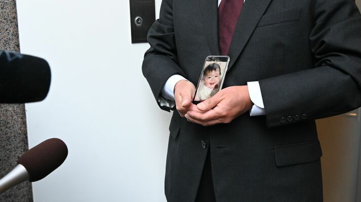 遺影を手に取材に応える愛美利ちゃんの父＝12日午後４時、東京都内