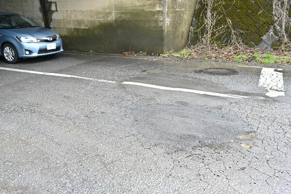 市道に穴が空いているのが見つかり、仮補修された陥没箇所（手前）＝２日午後、鹿沼市深津