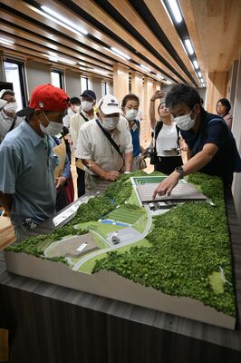ジオラマを見ながら施設の説明を受ける住民＝10日午後、那珂川町和見