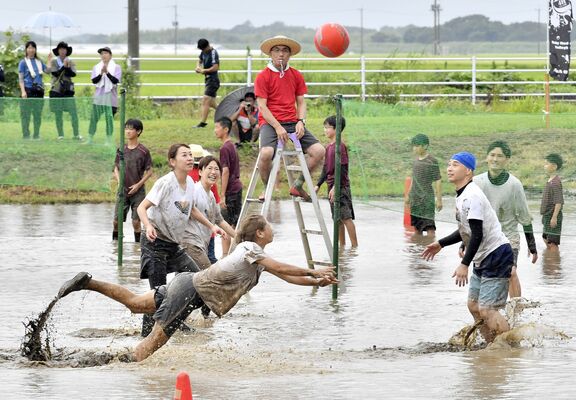 泥まみれでボールを追う選手ら
