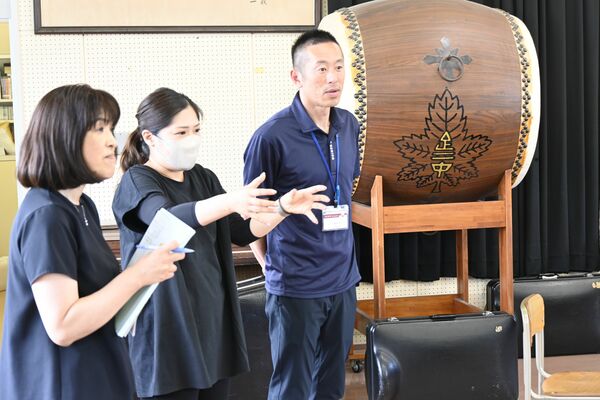 吹奏楽部の練習を視察する岡田さん（右）