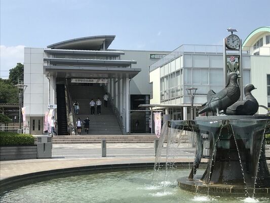 佐野駅前で日差しを避けて歩く人たち＝午後１時58分、佐野市