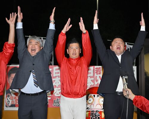小選挙区での初勝利を確実にし、万歳する藤岡隆雄氏（中央）＝27日午後８時15分、小山市城東１丁目