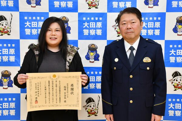 仲山署長（右）から感謝状を受け取った稲積さん