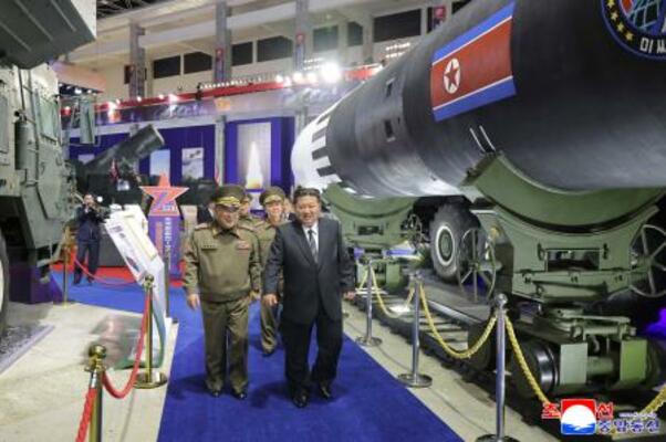 　最新兵器を並べた「武装装備展示会」に臨む北朝鮮の金正恩朝鮮労働党総書記（手前右）＝４日、平壌（朝鮮中央通信＝共同）