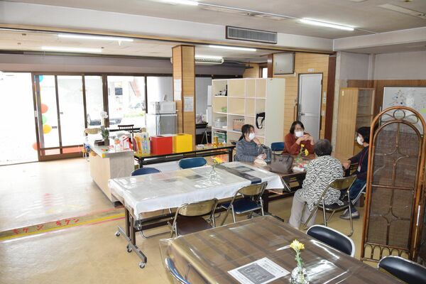 スタッフと談笑する利用者（手前）