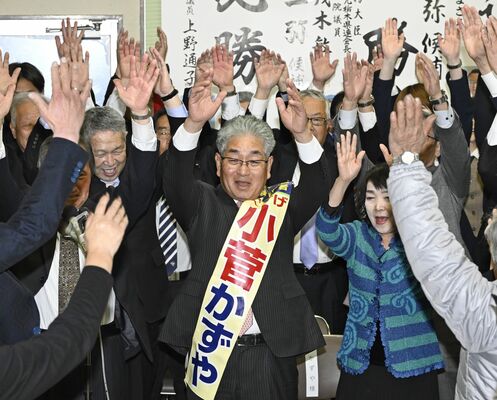 無投票で５選が決まり、万歳する小菅一弥氏（中央）＝24日午後５時40分、壬生町福和田、森田大地撮影