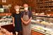洋菓子が並ぶ店内と山木久幸さん（右）