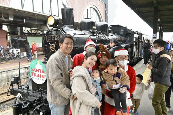 ＳＬの前でサンタと写真撮影する乗客