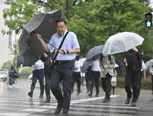 横殴りの雨の中、傘を差して横断歩道を渡る通勤者ら＝３日午前７時30分、宇都宮市塙田１丁目、加藤竜矢撮影