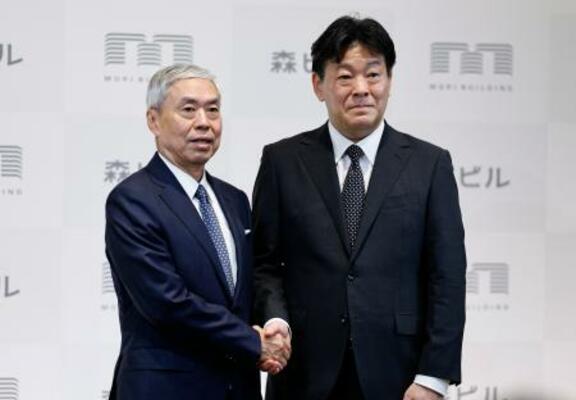 森ビル社長交代の記者会見を終え、握手する辻慎吾社長(左)と向後康弘氏=20日午後、東京都港区