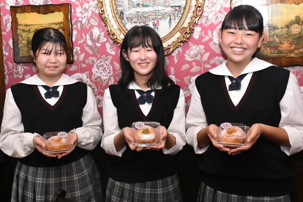 「黄金ももグルト」を持つ（左から）中三川さん、室井さん、増山さん