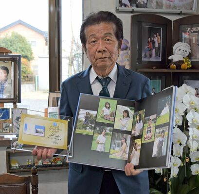 最優秀賞に輝いたアルバムなどを手にする小林さん