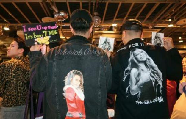 マライア・キャリーの写真をあしらったジャケットを着てサイン会に参加したファンら=東京都渋谷区