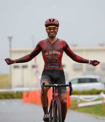 泥だらけになりながら両手を広げてゴールし、今季初勝利を喜ぶブリッツェンの沢田=宮城県亘理町