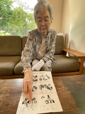 疎開した友人らと写った写真で、当時の自身を指さす飯沼さん＝７月、下野市小金井