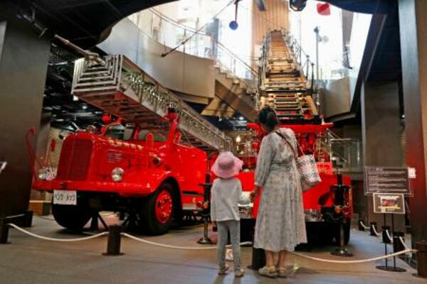 　「消防博物館」で消防車の展示を見る親子＝東京都新宿区