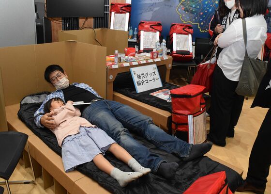 段ボールベッドを体験する来場者＝19日午前、宇都宮市