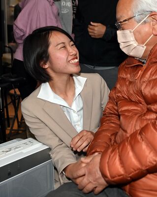 初当選し、支持者と握手する横須賀咲紀氏＝23日午後11時20分、宇都宮市東塙田１丁目
