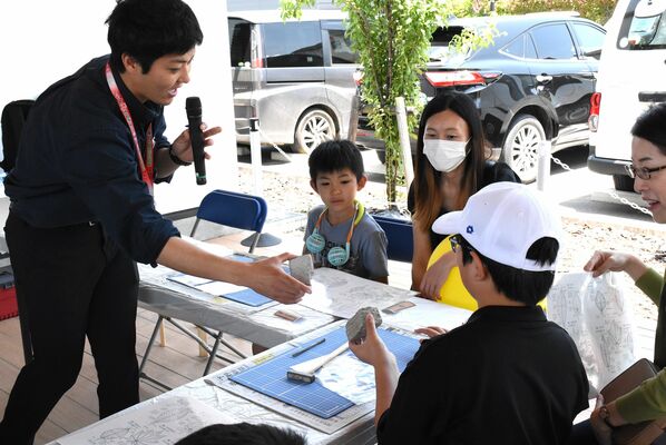 県立博物館学芸員の解説を受けながら化石の取り出しを体験する子どもたち＝８日午前、宇都宮市インターパーク６丁目