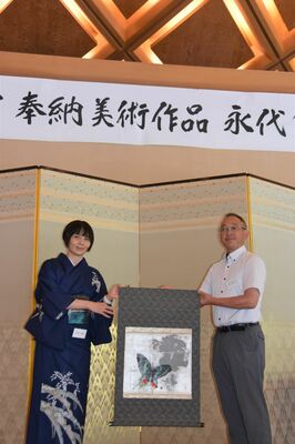 施設代表者（右）に作品を手渡す美術家