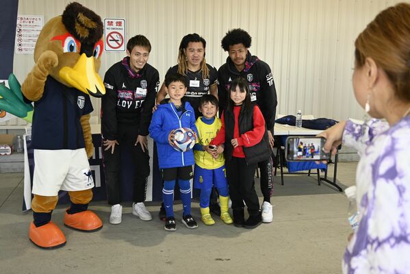 栃木シティの選手と写真を撮る子どもたち