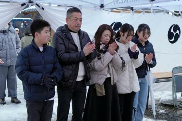初詣のため石川県輪島市の重蔵神社を訪れ、家族と手を合わせる大向正浩さん(左から2人目)=1日午前8時17分