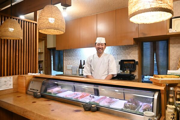 ウニなどの上質なネタが並んだカウンターに立つ大竹さん