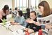 学生（両端）からインスタの使い方を教わる人たち