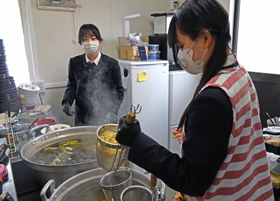 麺を湯切りする高校生ら