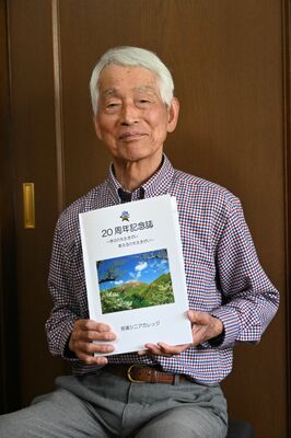 記念誌を手にする渡辺代表