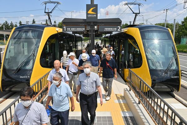 ＬＲＴの試乗を終え、下車する参加者たち＝19日午後０時15分、宇都宮市清原工業団地