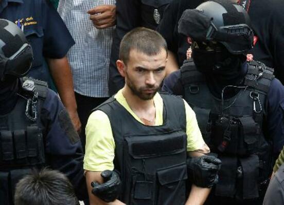警察官に付き添われるビラル・ムハンマド被告(中央)=2015年9月、タイ首都バンコク(AP=共同)