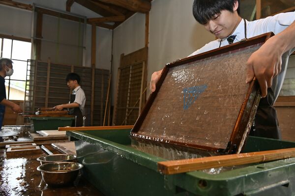すき桁から水分をふるい落とす生徒ら