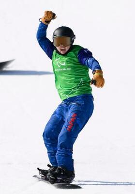 女子スノーボードクロス下肢障害決勝トーナメント1回戦 ゴールし、ガッツポーズする坂下恵里=コルティナダンペッツォ(共同)