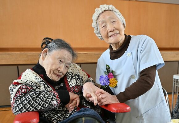 世界最高齢の女性理容師として３月にギネス認定された際、手を取り合って笑顔を見せる箱石さん（右）と長女充子さん＝那珂川町谷川