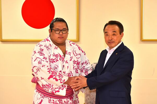 さくら市の花塚隆志市長（右）から祝福される生田目関＝１日午前、同市氏家