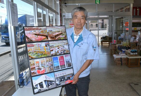 客からプレゼントされた写真パネルを手にする池森社長